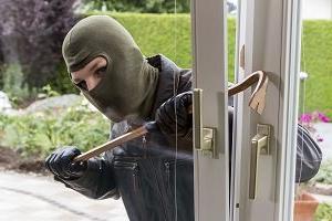 一个窃贼试图用撬棍从一扇开着的窗户破门而入